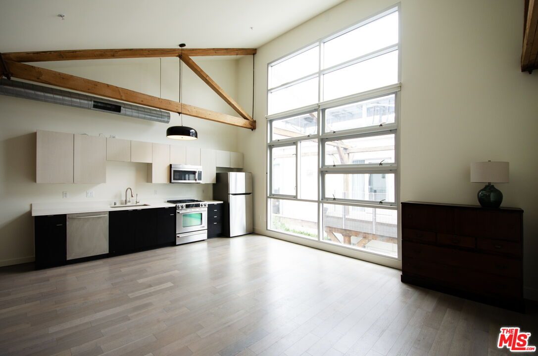 527 Molino Street, Unit 217 Los Angeles, CA 90013 - Photo 2 of 28 a large kitchen with stainless steel appliances granite countertop a stove and a refrigerator