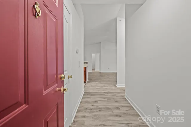 a view of a hallway with wooden floor and a shower