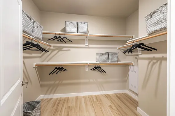 a view of walk in closet with clothes and shoes