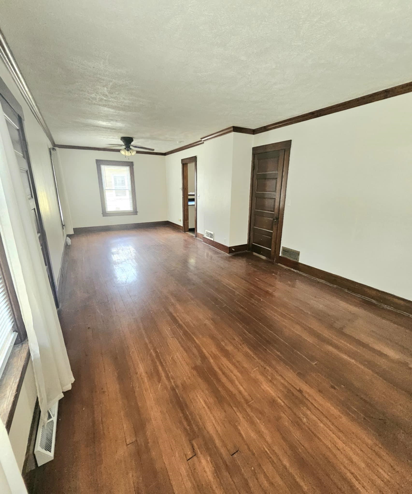 1219 Hackett Street Beloit, WI 53511 - Photo 3 of 19 an empty room with wooden floor and windows