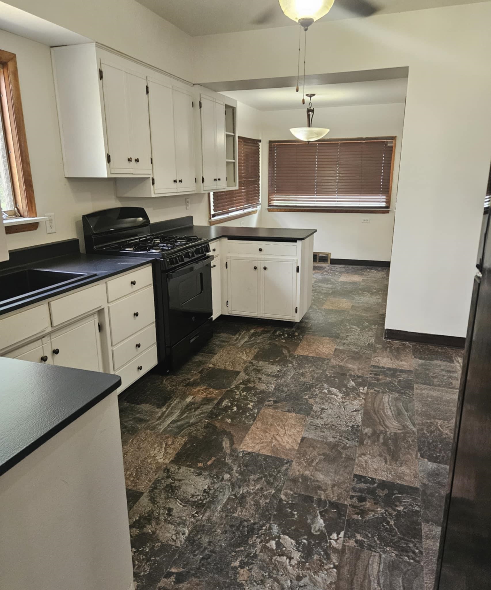 1219 Hackett Street Beloit, WI 53511 - Photo 7 of 19 a kitchen with a sink stove and cabinets