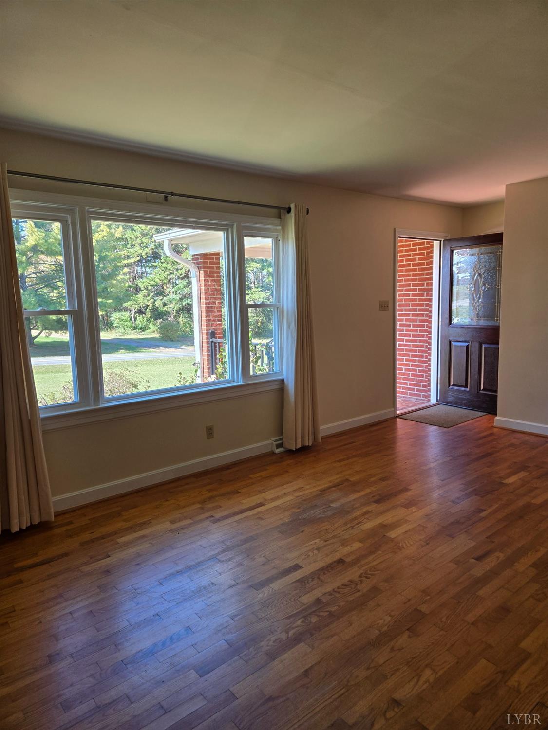 8968 Red House Road Appomattox, VA 24522 - Photo 11 of 31 a view of an empty room with wooden floor and a window