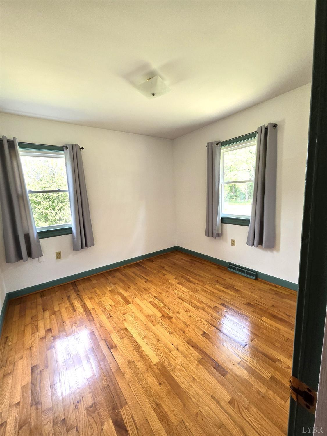 8968 Red House Road Appomattox, VA 24522 - Photo 13 of 31 an empty room with wooden floor and windows