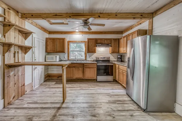 a kitchen with stainless steel appliances granite countertop a stove a sink and a refrigerator