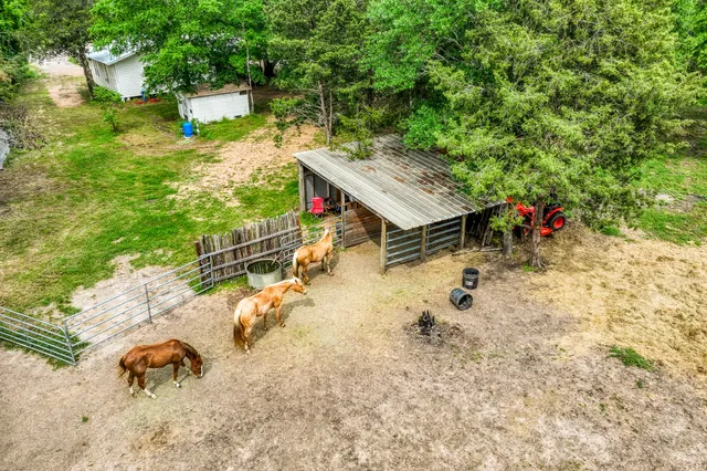 an aerial view of a house with yard and patio