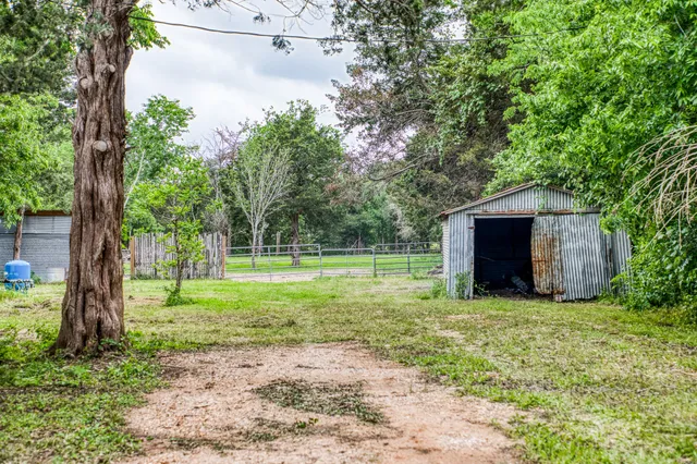 a view of a house with backyard and trees