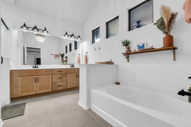 a bathroom with a tub sink and mirror