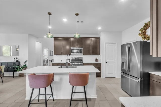 a kitchen with stainless steel appliances kitchen island a refrigerator and a sink