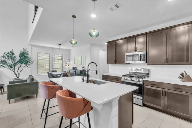 a large kitchen with kitchen island a stove a sink a table and chairs