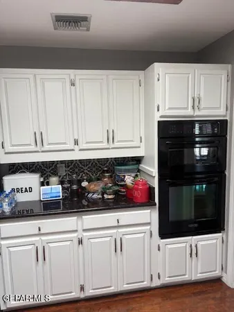 a kitchen with white cabinets and appliances
