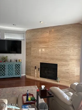 a living room with couches bookshelf and a flat screen tv