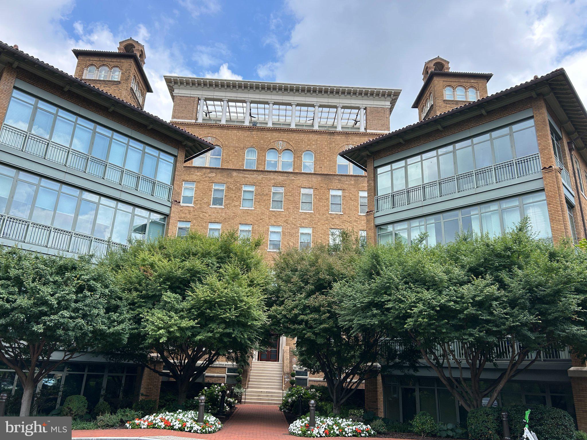 2425 L Street Northwest, Unit 421 Washington, DC 20037 - Photo 1 of 18 Charming brick facade with lush greenery.