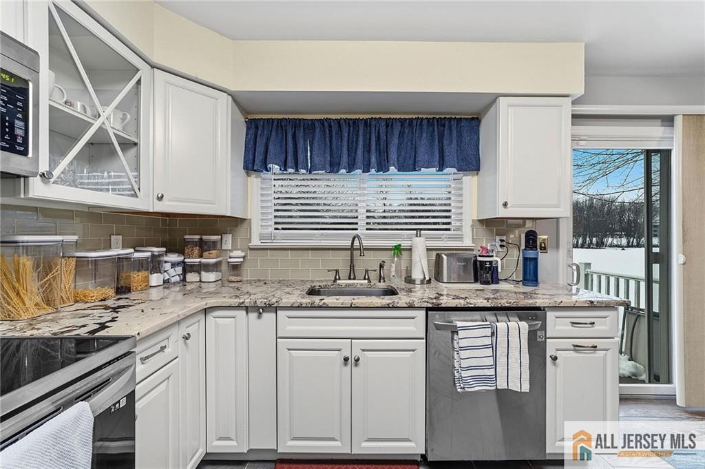 491A Delair Road, Unit 491B Monroe Township, NJ 08831 - Photo 7 of 22 a kitchen with granite countertop a sink a stove and cabinets