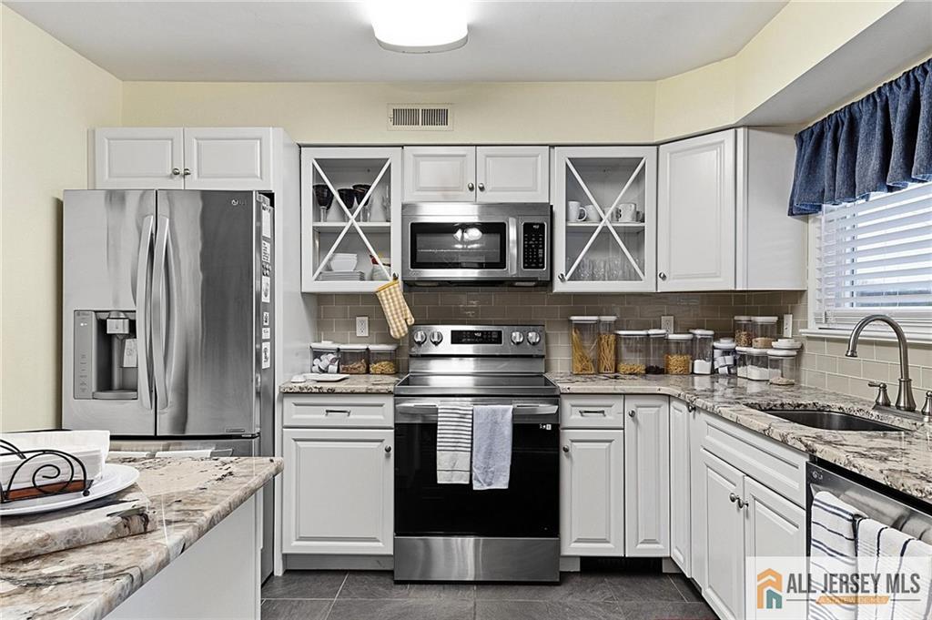 491A Delair Road, Unit 491B Monroe Township, NJ 08831 - Photo 8 of 22 a kitchen with stainless steel appliances granite countertop a sink stove and refrigerator