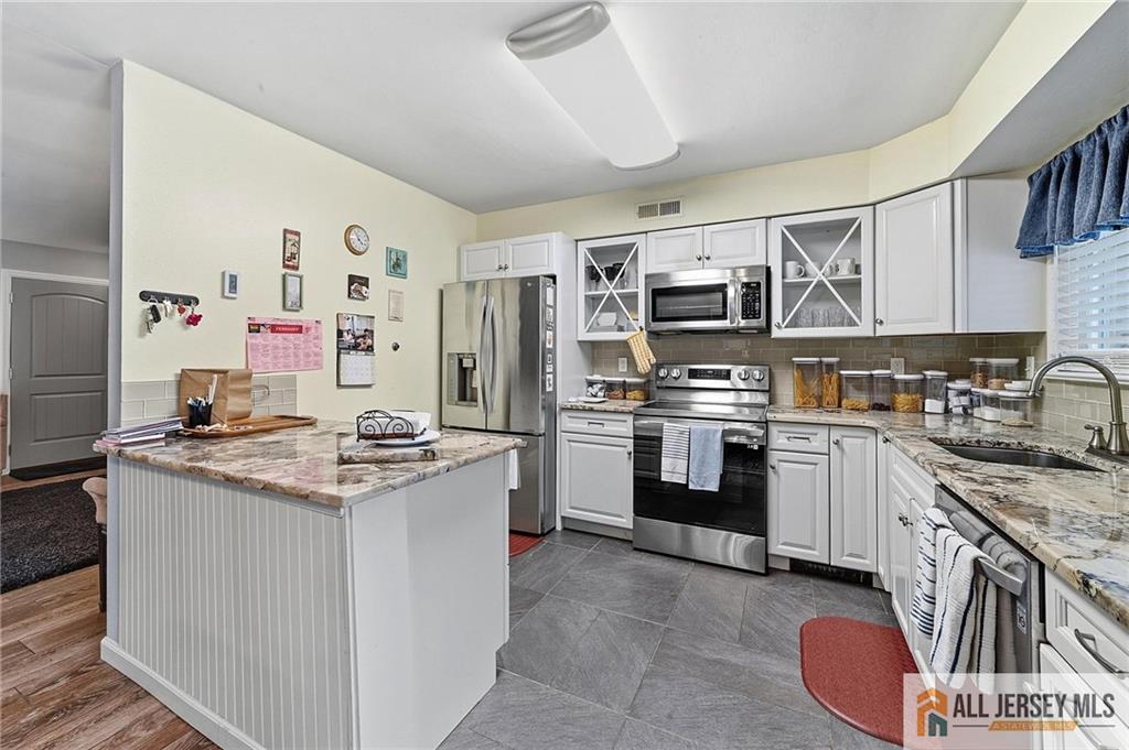 491A Delair Road, Unit 491B Monroe Township, NJ 08831 - Photo 9 of 22 a kitchen with stainless steel appliances granite countertop a stove sink and refrigerator