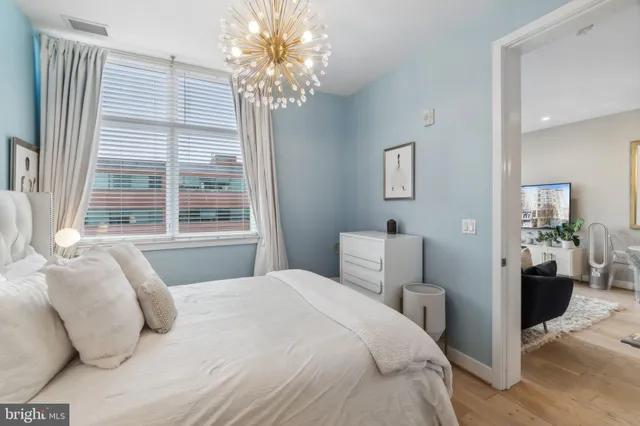 a bedroom with a large bed and a chandelier