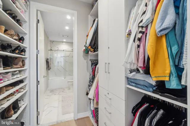 a view of walk in closet with clothes and shoes