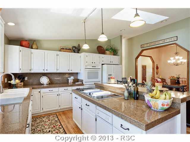 14575 Raton Road Colorado Springs, CO 80921 - Photo 5 of 25 Kitchen has plenty of prep space, Range top with grill and griddle, granite countertops. Lots of cabinet space here as well as multiple closets and pantry for storage. The window over the sink looks over the backyard , swingset, playhouse and deck .
