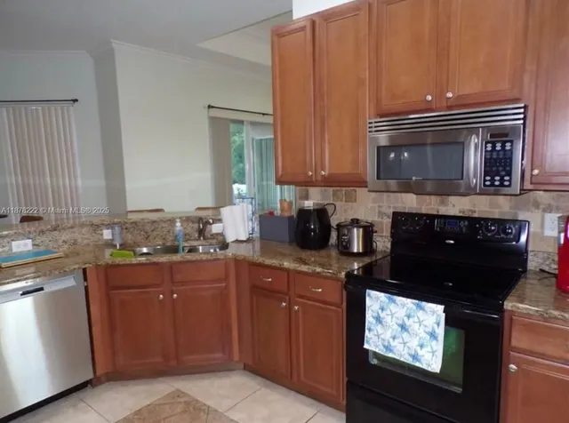 a kitchen with granite countertop a stove top oven microwave and cabinets