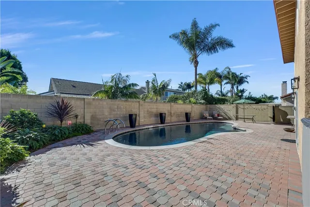 a view of a house with backyard sitting area and swimming pool