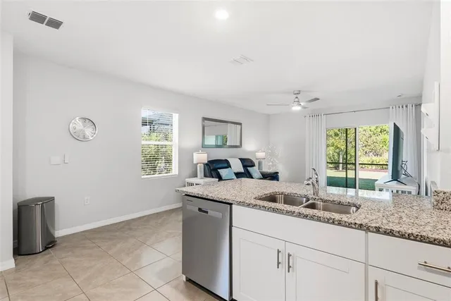 a bathroom with a granite countertop sink and a window