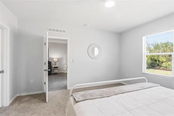 a spacious bedroom with a bed and a window