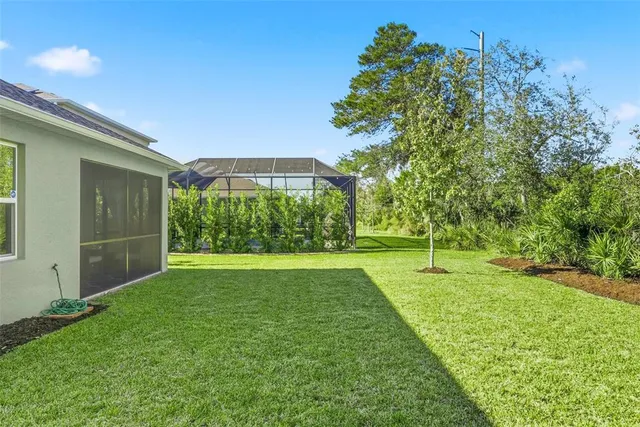 a view of yard with green space and trees in the background