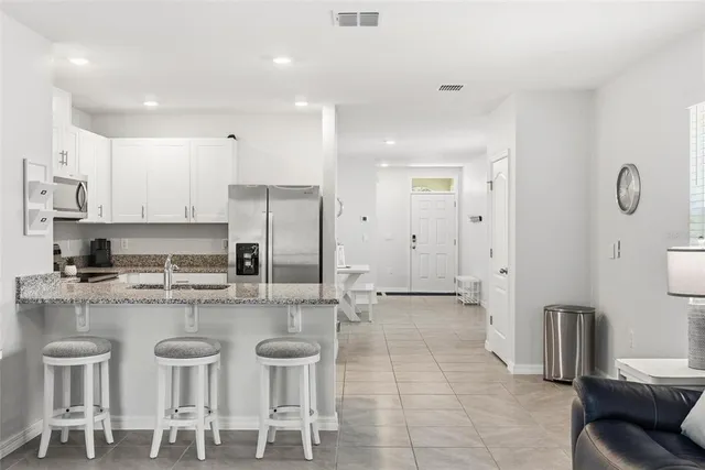 a large kitchen with stainless steel appliances granite countertop a stove a sink and a refrigerator