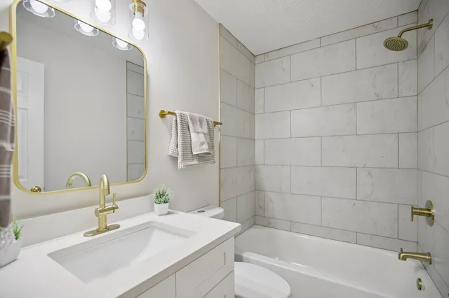 a bathroom with a sink mirror toilet and bathtub
