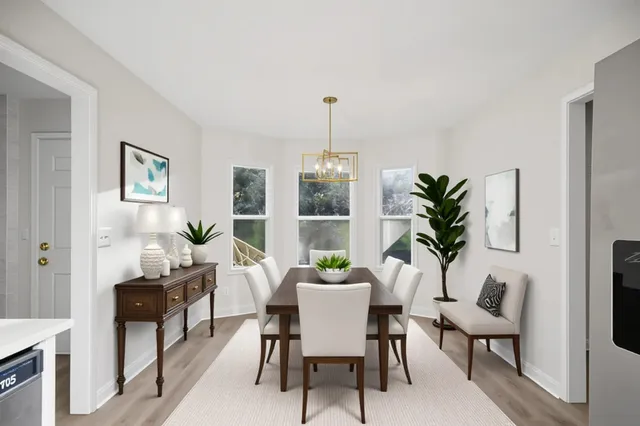a dining room with furniture potted plants and wooden floor