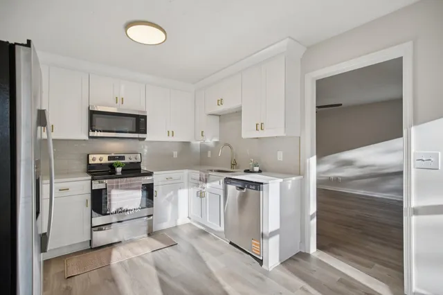 a kitchen with stainless steel appliances granite countertop a stove a sink and a refrigerator