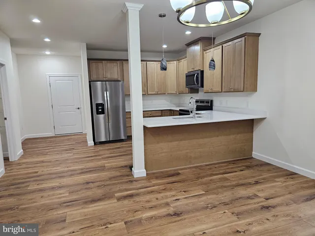 a view of kitchen with cabinets appliances and wooden floor