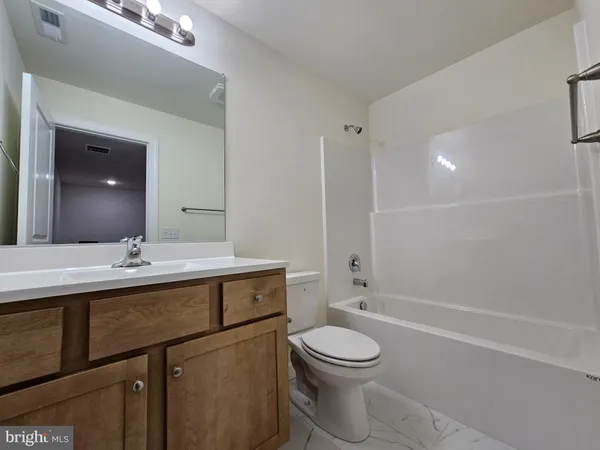 a bathroom with a sink a toilet a mirror and vanity