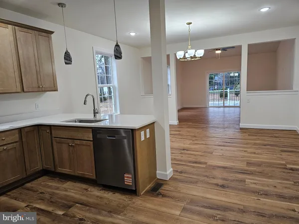 a kitchen with kitchen island granite countertop wooden cabinets and sink