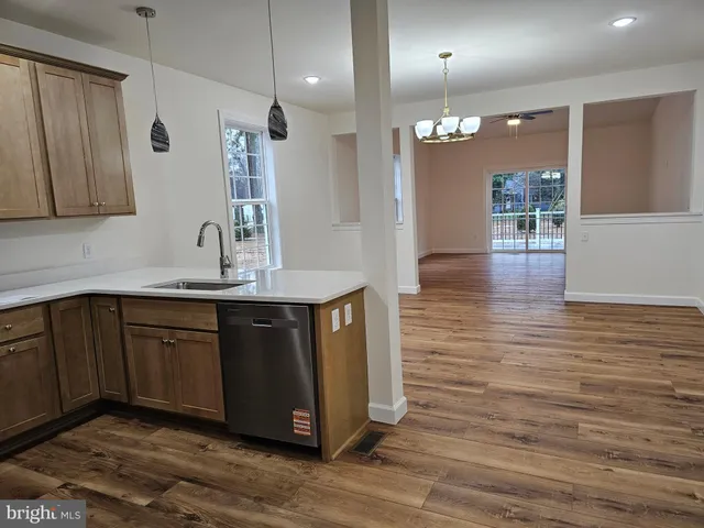 a kitchen with kitchen island granite countertop wooden cabinets and sink