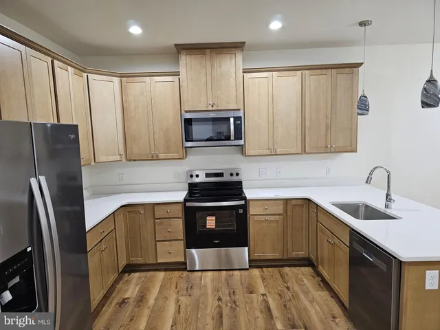 a kitchen with stainless steel appliances granite countertop a stove a sink dishwasher a refrigerator and a microwave