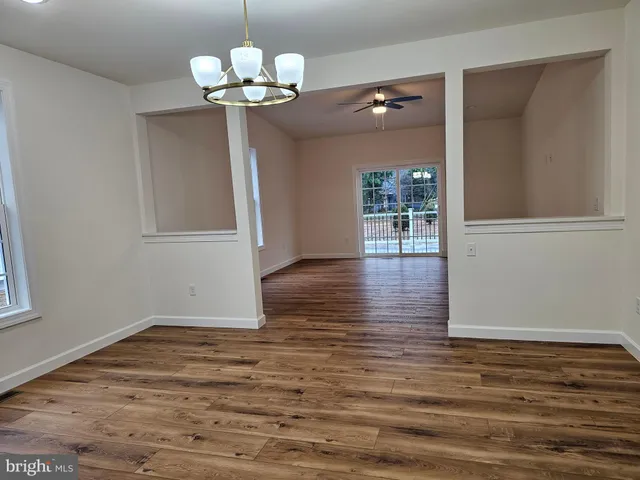 a view of a room with wooden floor and chandelier