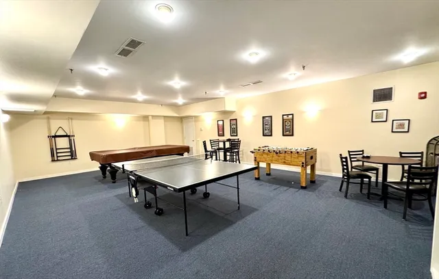 a room with furniture pool table and a flat screen tv