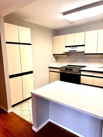 a kitchen with stainless steel appliances a refrigerator a sink and a large window