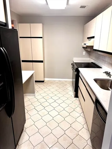 a kitchen with a sink a refrigerator and a stove