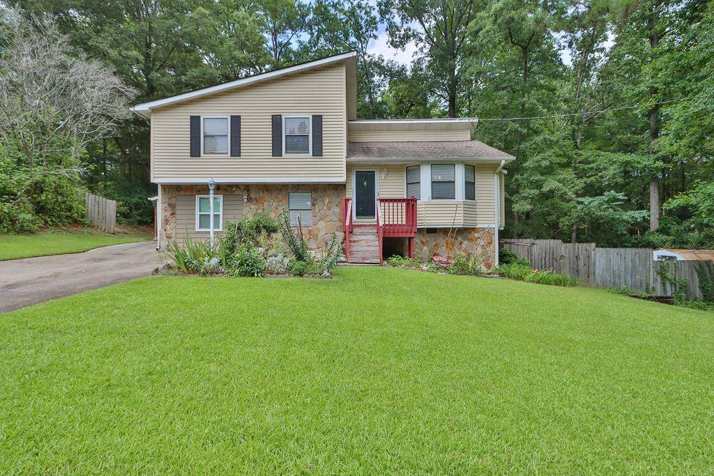 a front view of a house with a yard and trees