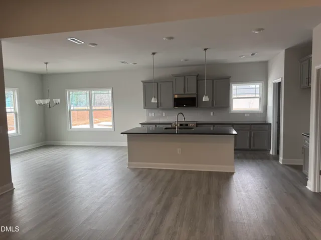 a large kitchen with stainless steel appliances granite countertop a large stove a sink dishwasher and a oven with wooden floors