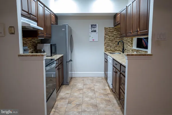 a kitchen with stainless steel appliances granite countertop a refrigerator and a stove