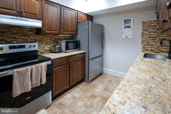 a kitchen with stainless steel appliances granite countertop a refrigerator stove and sink
