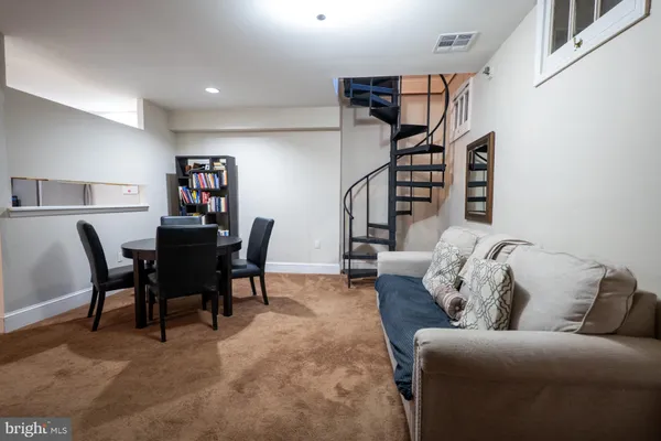 a living room with furniture and a dining table with projector