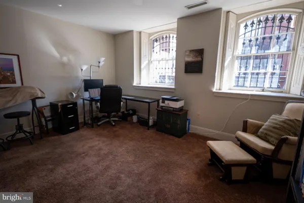 a view of a livingroom with workspace and a window