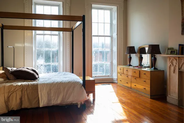 a bedroom with a bed and large windows