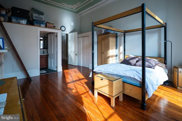 a bedroom with bed and wooden floor