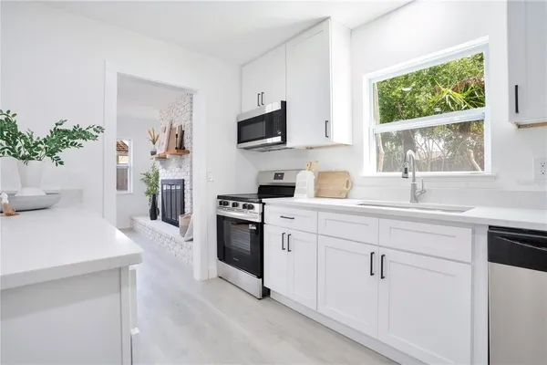 a kitchen with white cabinets and a window