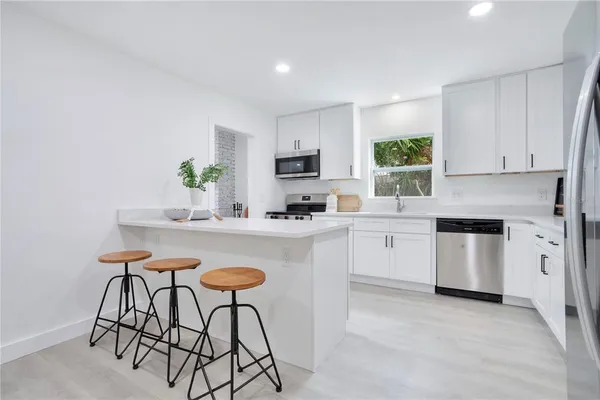 a kitchen with a table chairs sink and cabinets